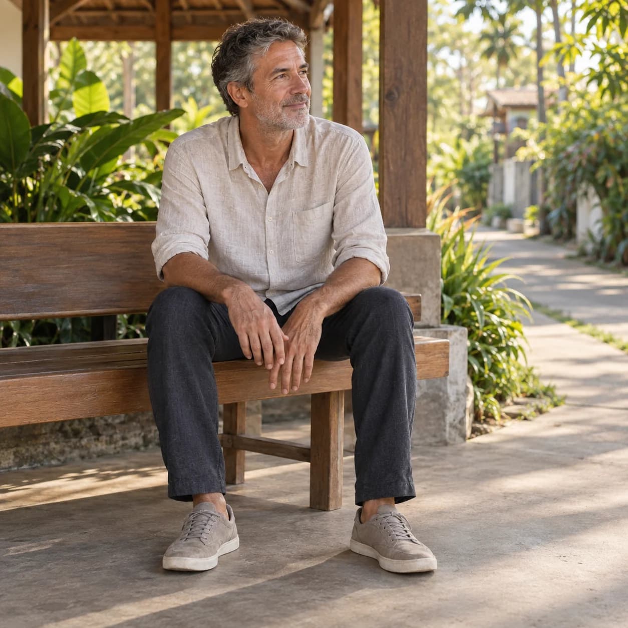 An adult resting on a wooden bench beside a walking path